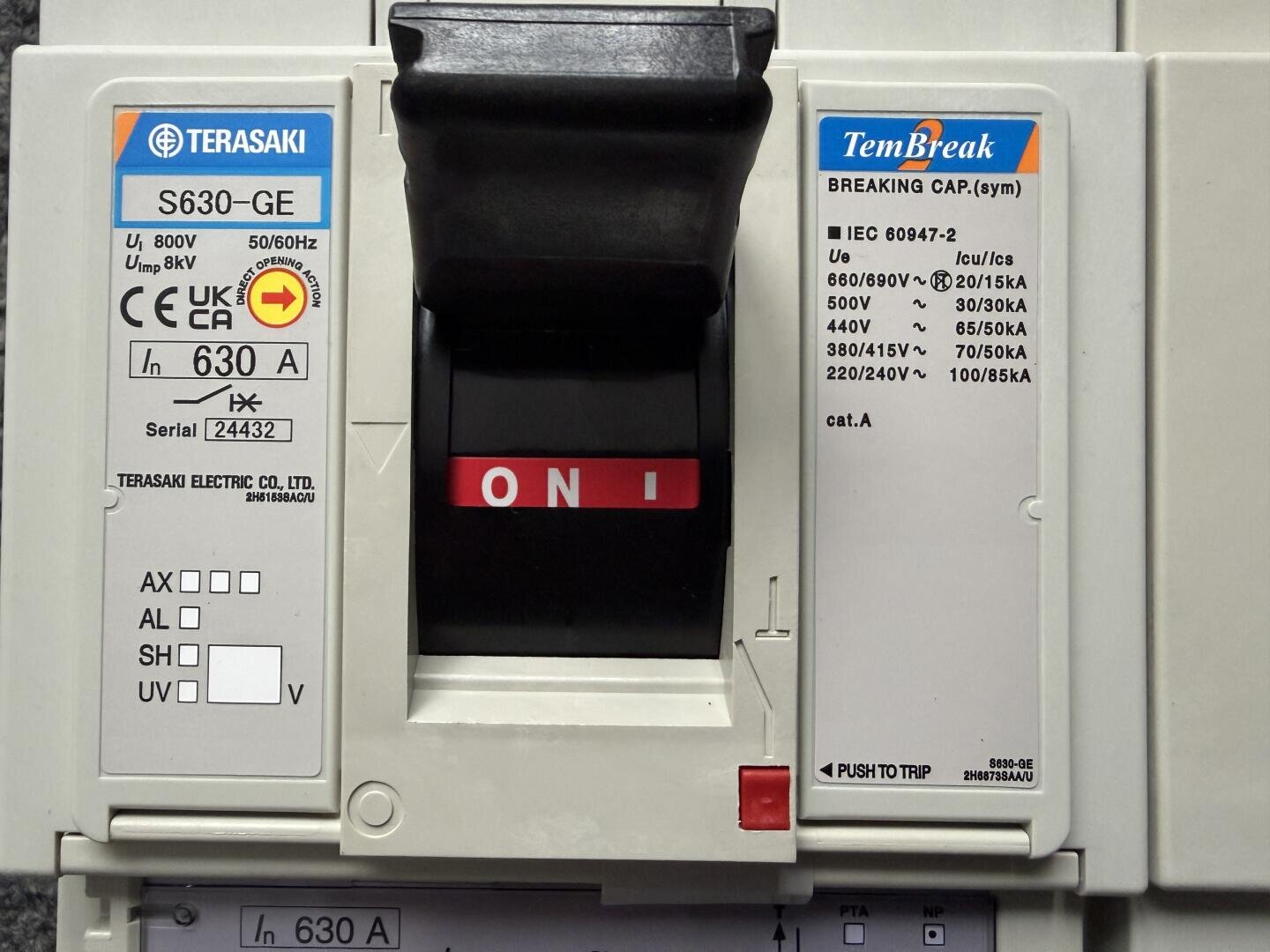 Nahaufnahme eines Terasaki TemBreak-Schutzschalters mit einem schwarzen Schalter in der Stellung ON. Auf den Etiketten sind technische Daten wie Spannung, Stromstärke und andere elektrische Werte angegeben.