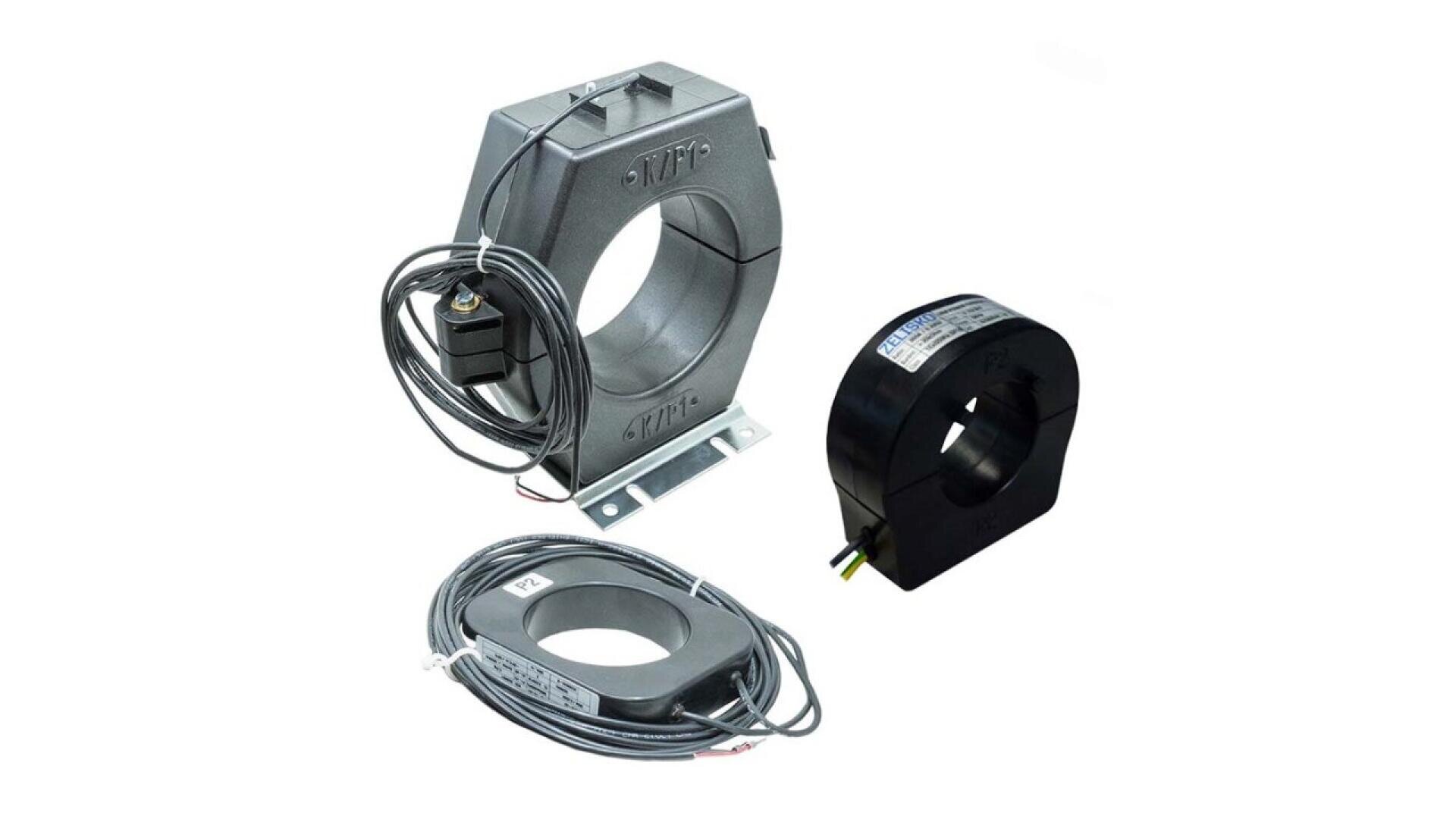 Three different types of electrical current transformers with attached wires, displayed on a white background. Each transformer varies in shape and size, featuring circular central openings.