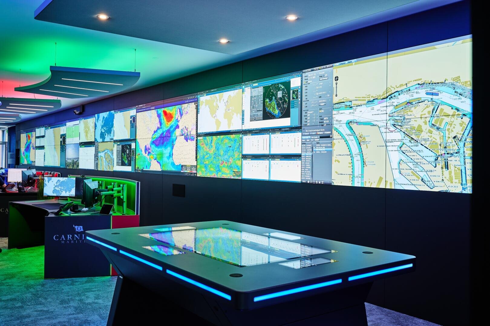 Daten aus allen Teilen der Erde fliessen im Fleet Operations Center von Carnival Maritime in Hamburg zusammen. Grossbildtechnik, ein IP-basiertes KVM-System und HMI (Human Machine Interfaces) unterstützen die Arbeit der Operator Crew.
Foto: JST – Jungmann Systemtechnik® 
