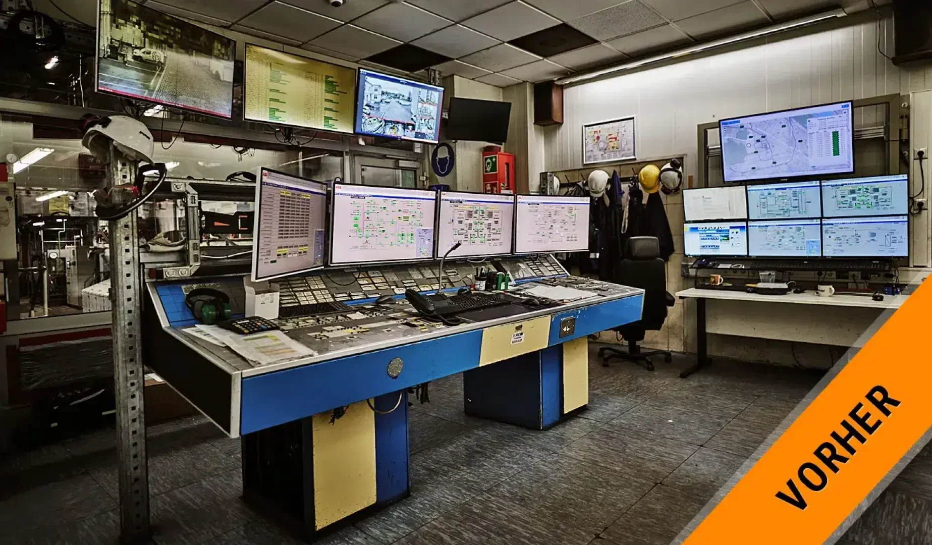 Ein Kontrollraum mit mehreren Monitoren, auf denen Daten und Überwachungsmaterial angezeigt werden, verschiedene Geräte auf Schreibtischen, Schutzhelme in Regalen und ein orangefarbenes VORHER-Banner in der Ecke.