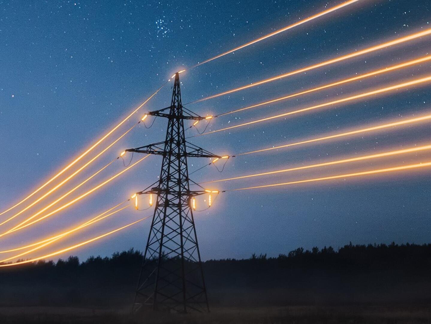A power line tower stands against a night sky, with glowing orange light trails representing electricity streaming along the cables, and stars visible above the dark landscape.