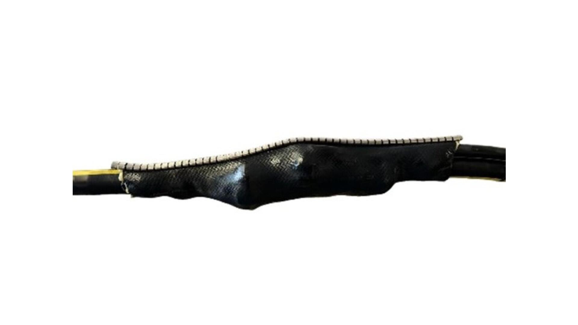 A close-up of a cable joint covered with a black protective sleeve and a metallic strip running along the top, connecting two sections of an electrical cable.