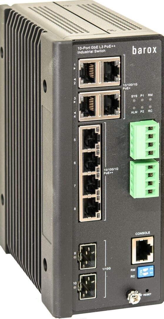Ein schwarzer industrieller Netzwerk-Switch mit mehreren Ethernet-Ports, zwei grünen Anschlussklemmen, LED-Anzeigen, SFP-Steckplätzen und beschrifteten Anschlüssen auf der Vorderseite.