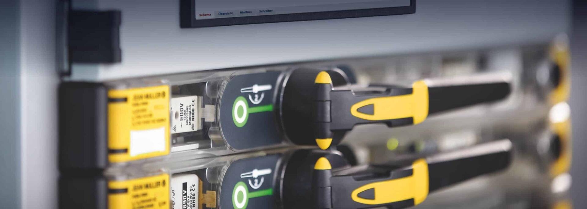 Nahaufnahme von zwei Serverfestplatten mit gelben und schwarzen Griffen, die in einem Serverrack installiert sind; zu sehen sind Etiketten und grüne Betriebs-/Statusanzeigen.