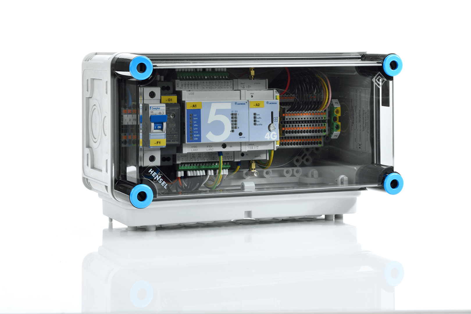 Ein transparenter elektrischer Schaltkasten mit sichtbaren Kabeln, Leiterplatten und beschrifteten Bauteilen, der mit vier blauen Schrauben an jeder Ecke befestigt ist und auf einer weißen, reflektierenden Oberfläche steht.