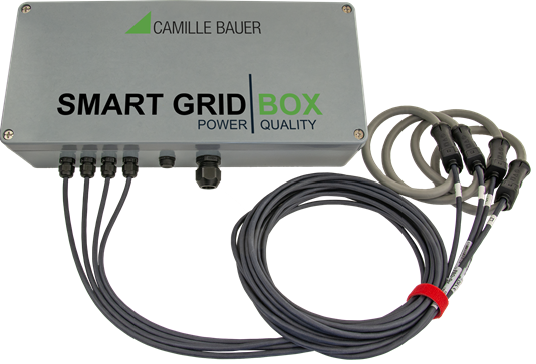 Ein rechteckiges Metallgerät mit der Aufschrift CAMILLE BAUER SMART GRID BOX POWER QUALITY mit fünf angeschlossenen Kabeln auf der linken Seite und drei mit einem roten Band gesicherten Kabelschleifen auf der rechten Seite.